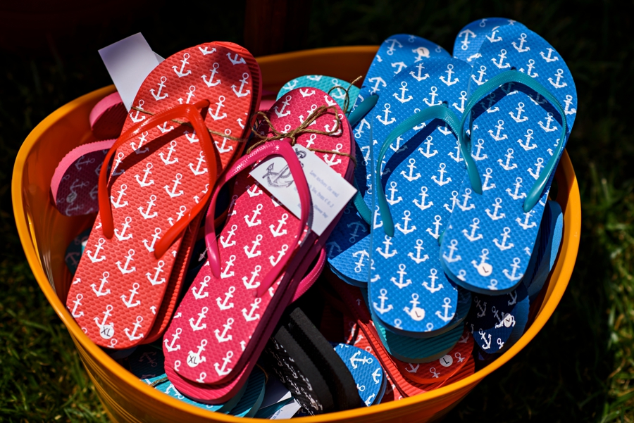 A basket of blue and pink flip flops with anchors on them.